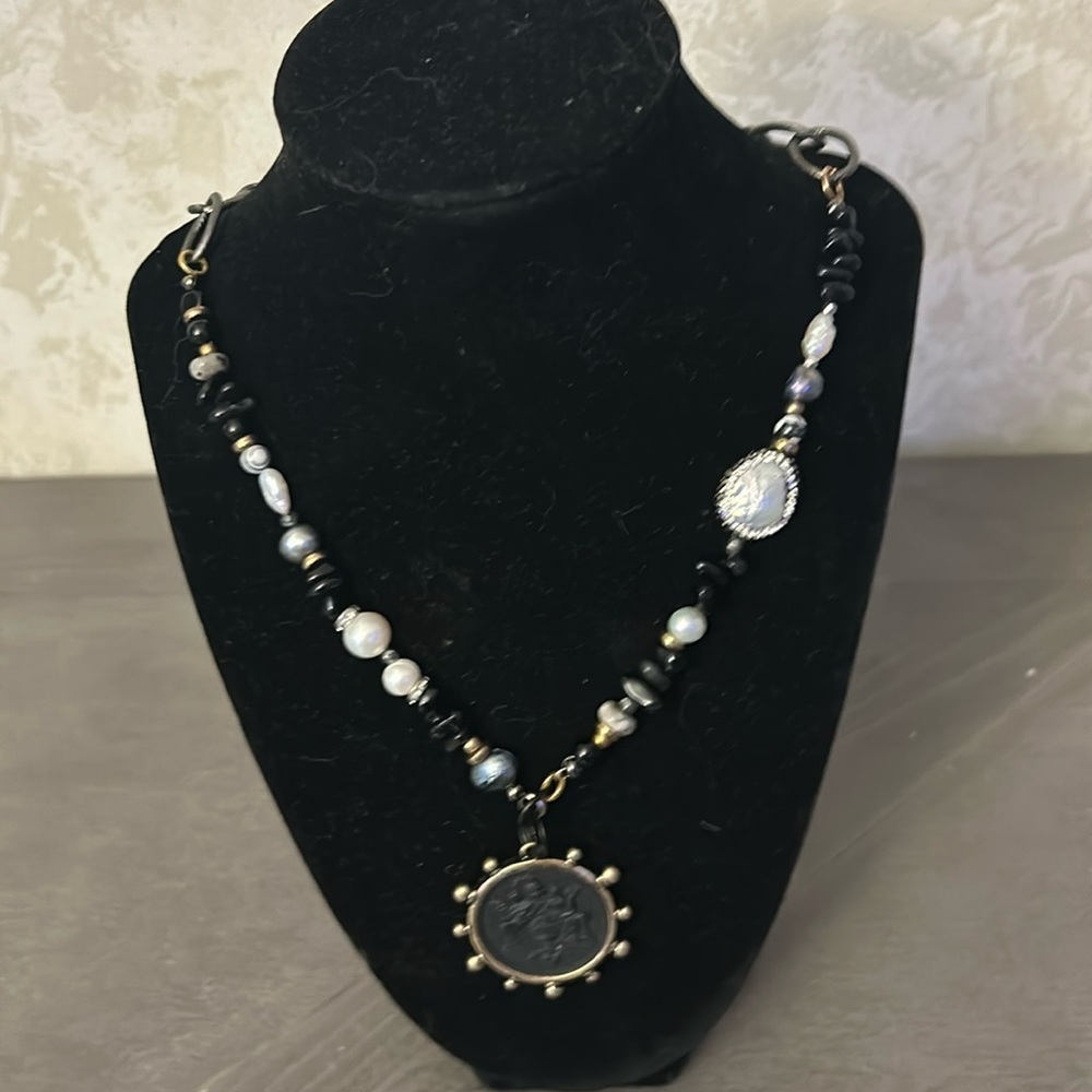Stunning one of a ind necklace with black emblem.